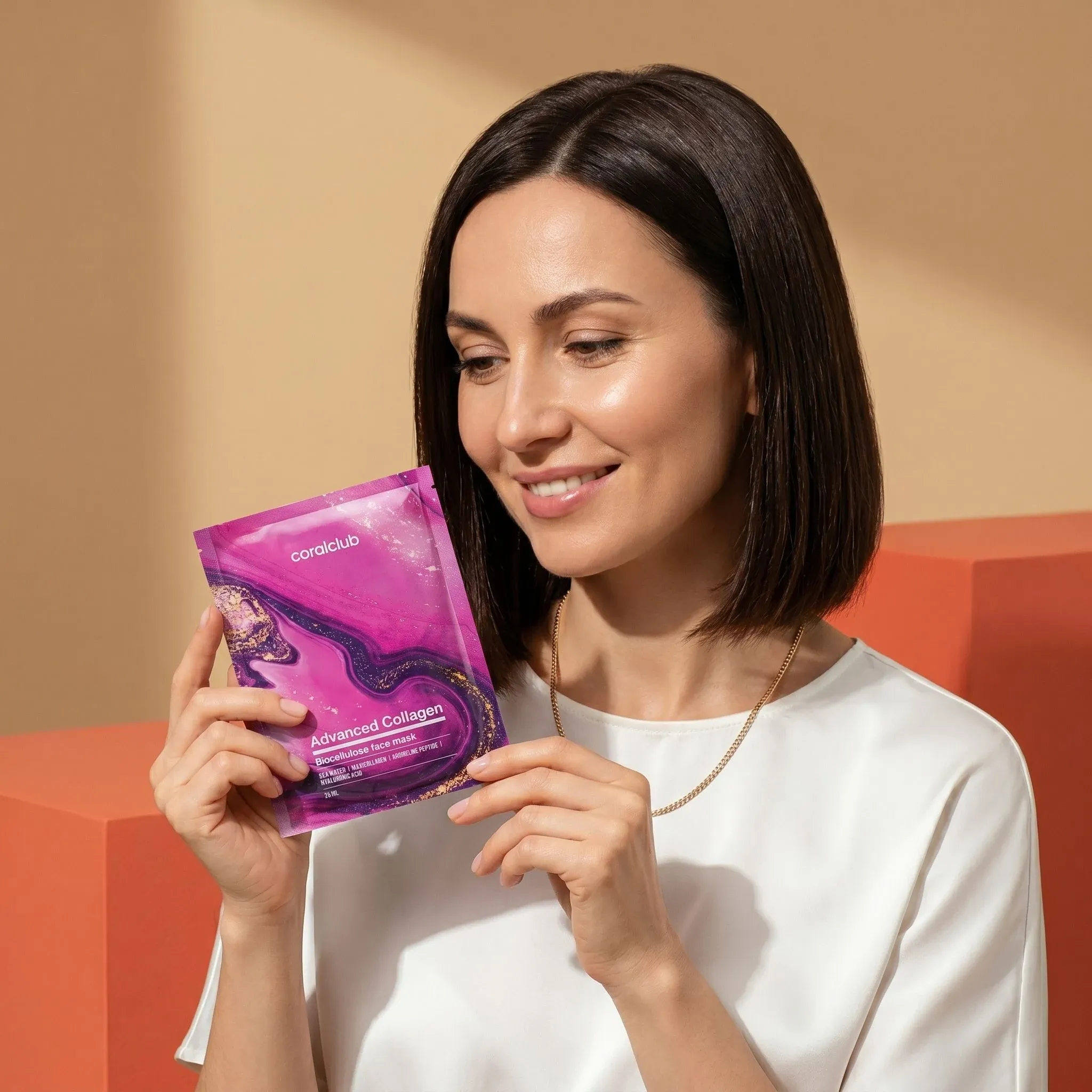 Advanced Collagen Biocellulose Facial Mask lifestyle image with a woman holding the product, showcasing its vibrant packaging.