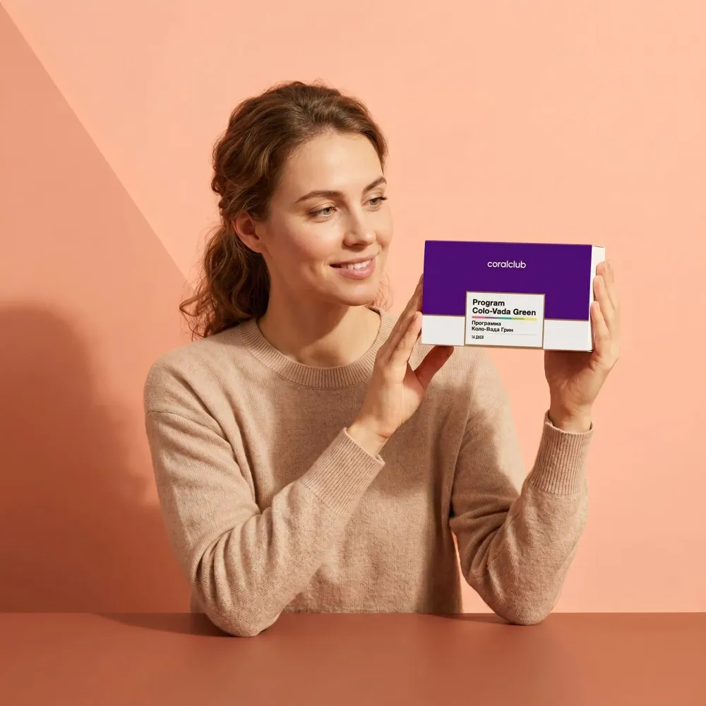 Woman holding Colo-Vada Green box in a lifestyle setting with a soft pink background.