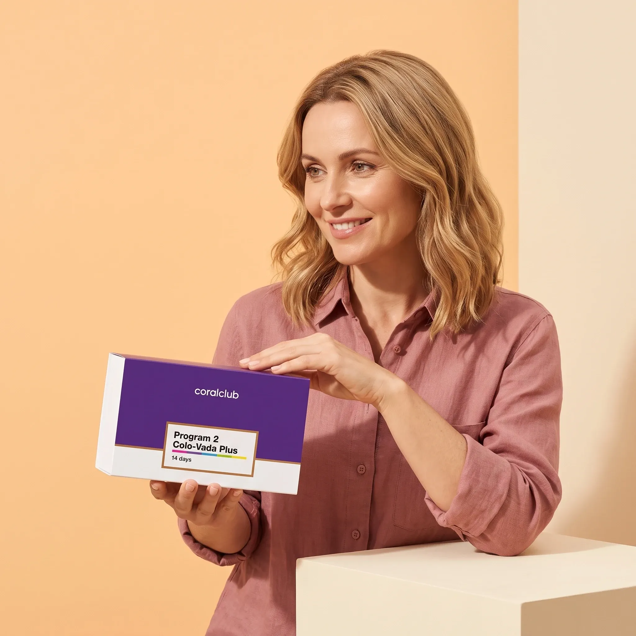Woman holding the Colo-Vada Plus 14-day program box in a warm, bright lifestyle setting.