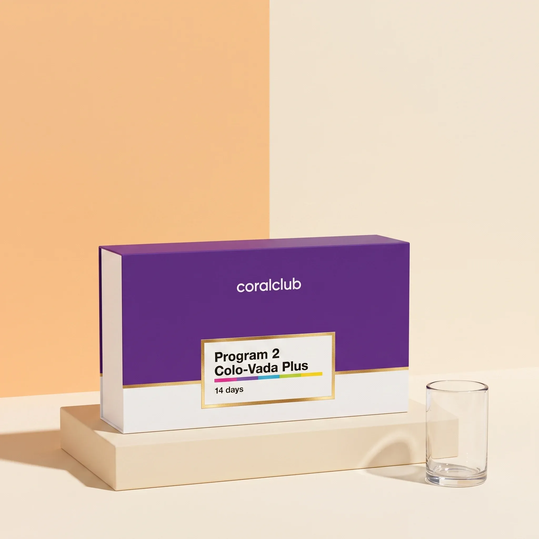 Colo-Vada Plus program box on a cream plinth beside an empty drinking glass.