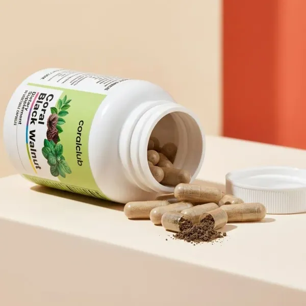 Coral Black Walnut supplement bottle with spilled capsules and powder detail.