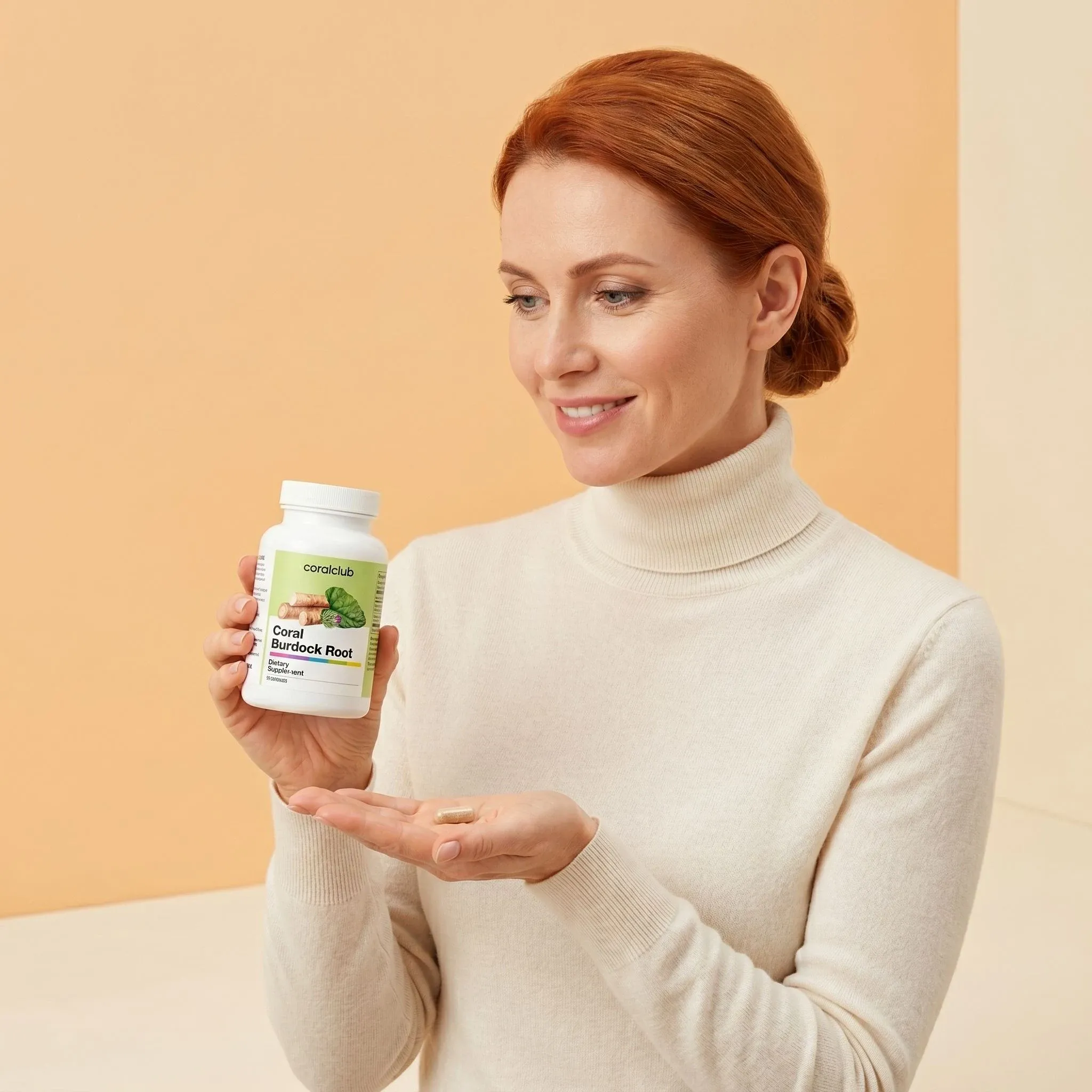 Woman holding Coral Burdock Root supplement bottle in a lifestyle setting, wearing a cream sweater.