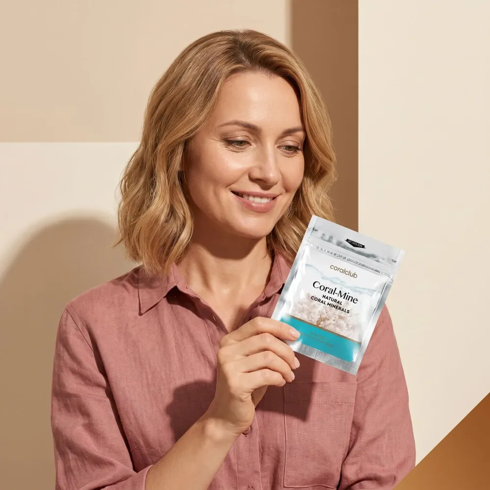 Woman holding Coral Mine supplement pouch in a modern lifestyle setting.