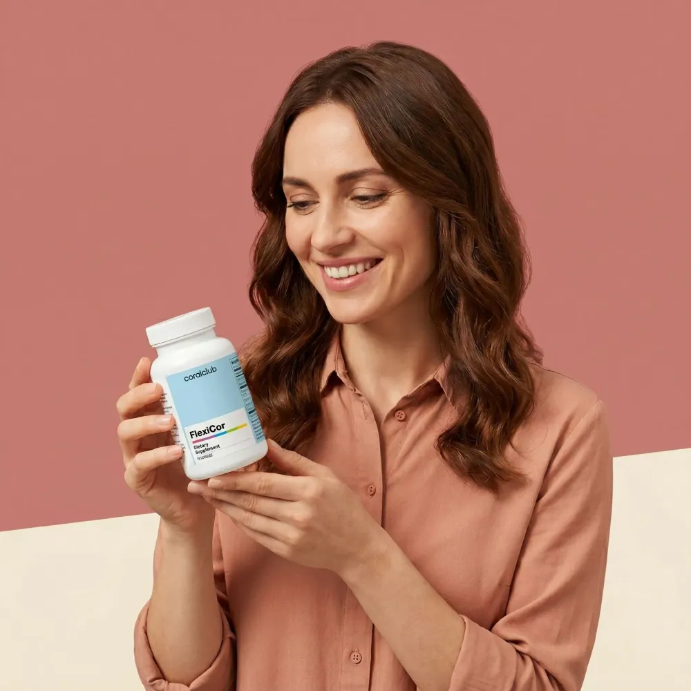 Woman holding FlexiCor supplement bottle against a pastel background.