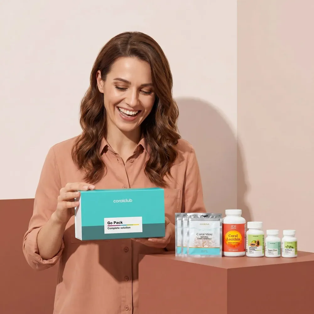 Healthy Start Pack lifestyle image featuring a woman happily holding the product box with various supplements displayed.