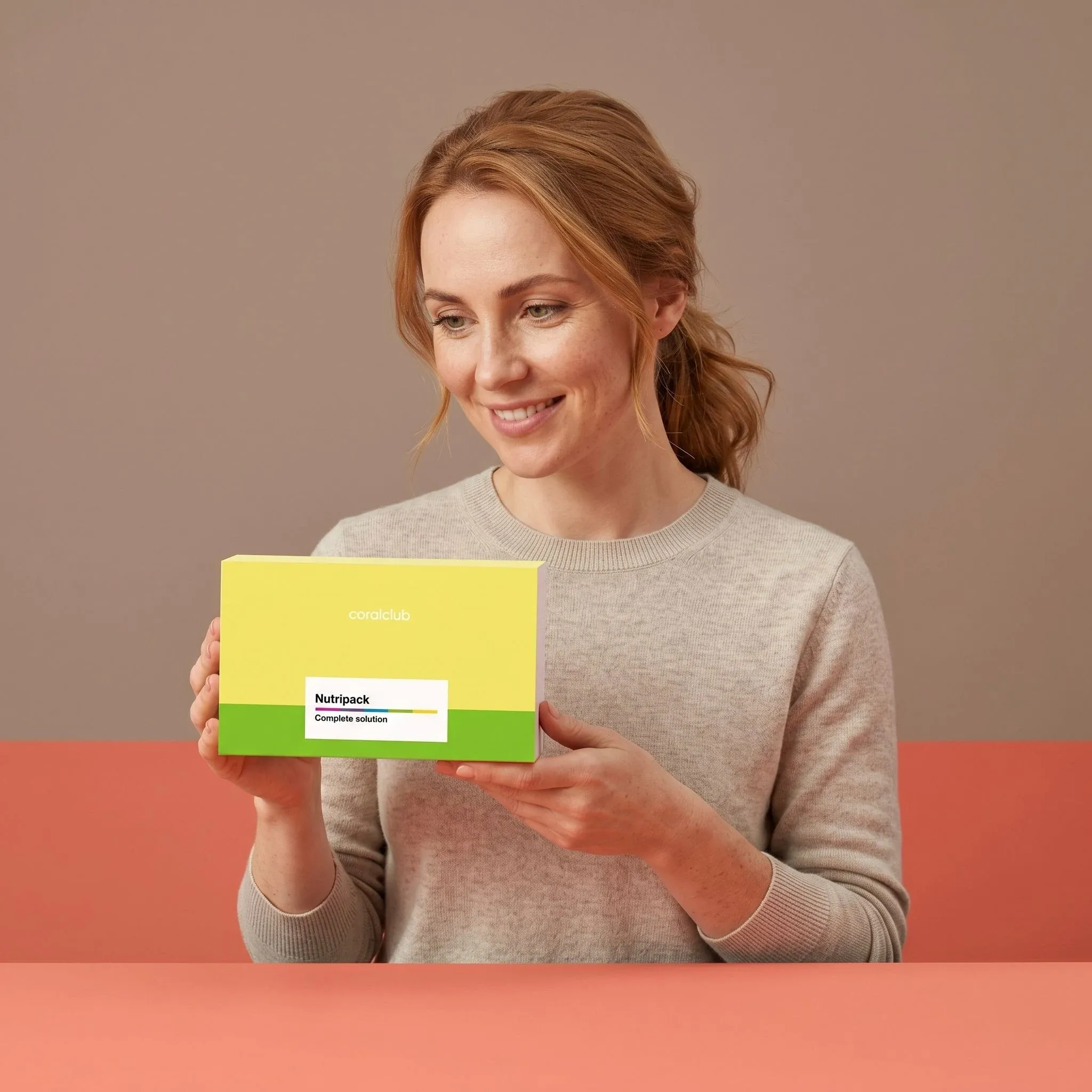 Woman holding Nutripack box, showcasing a lifestyle setting with soft pastel background.