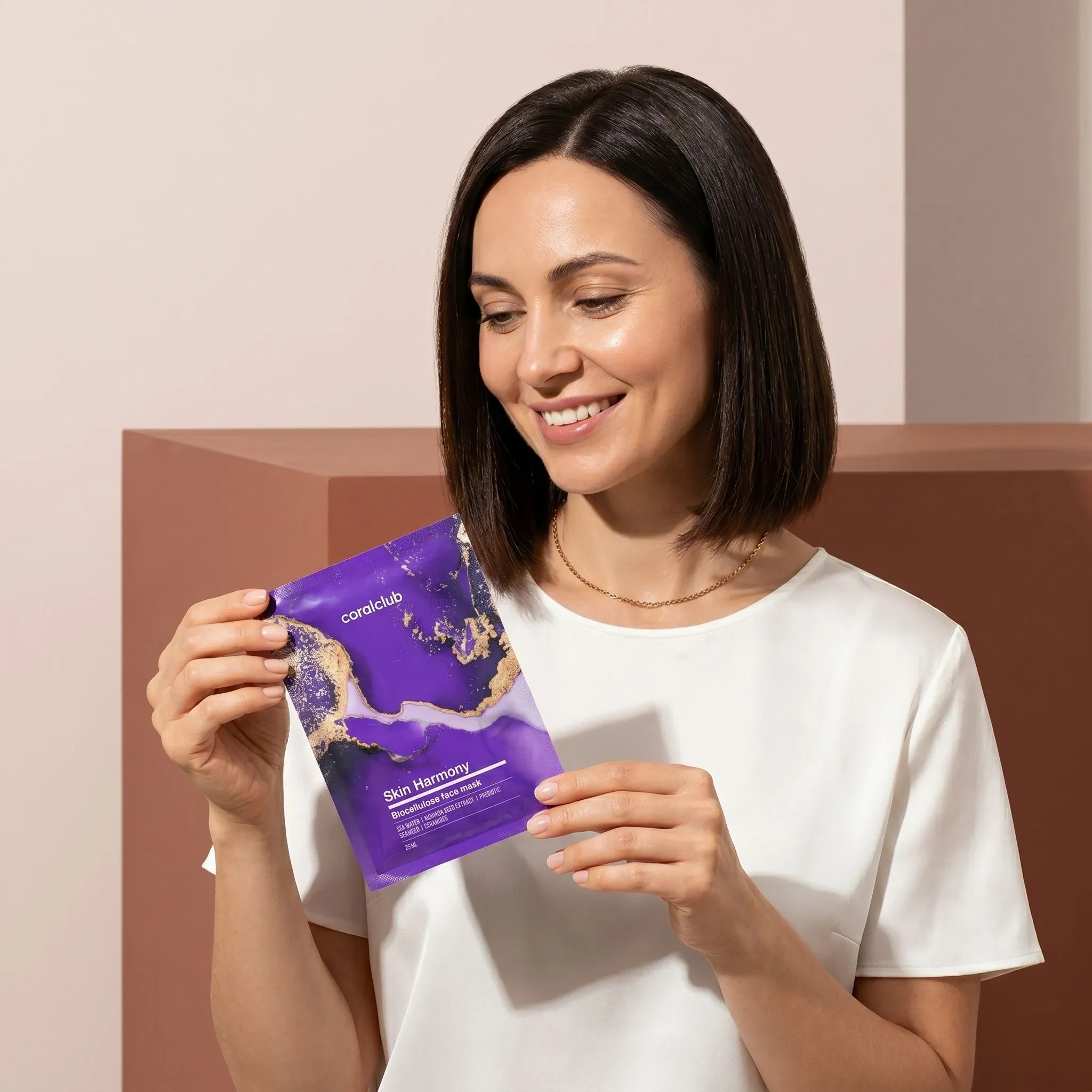Model holding Skin Harmony Biocellulose Facial Mask in a lifestyle setting, showcasing the packaging design.