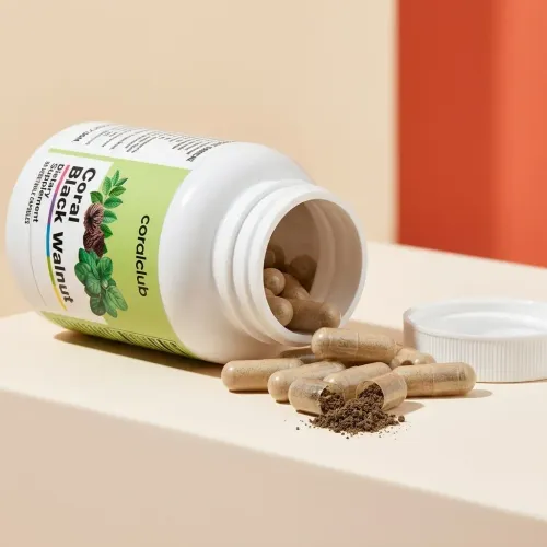 Coral Black Walnut supplement bottle with spilled capsules and powder detail.