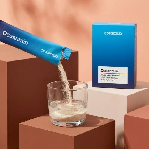 Oceanmin dietary supplement powder being poured into a glass, with packaging in a modern setting.
